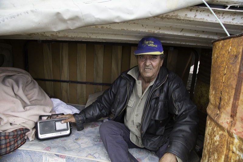 Cristín, junto a su radio, en la caseta que se ha construido para dormir.